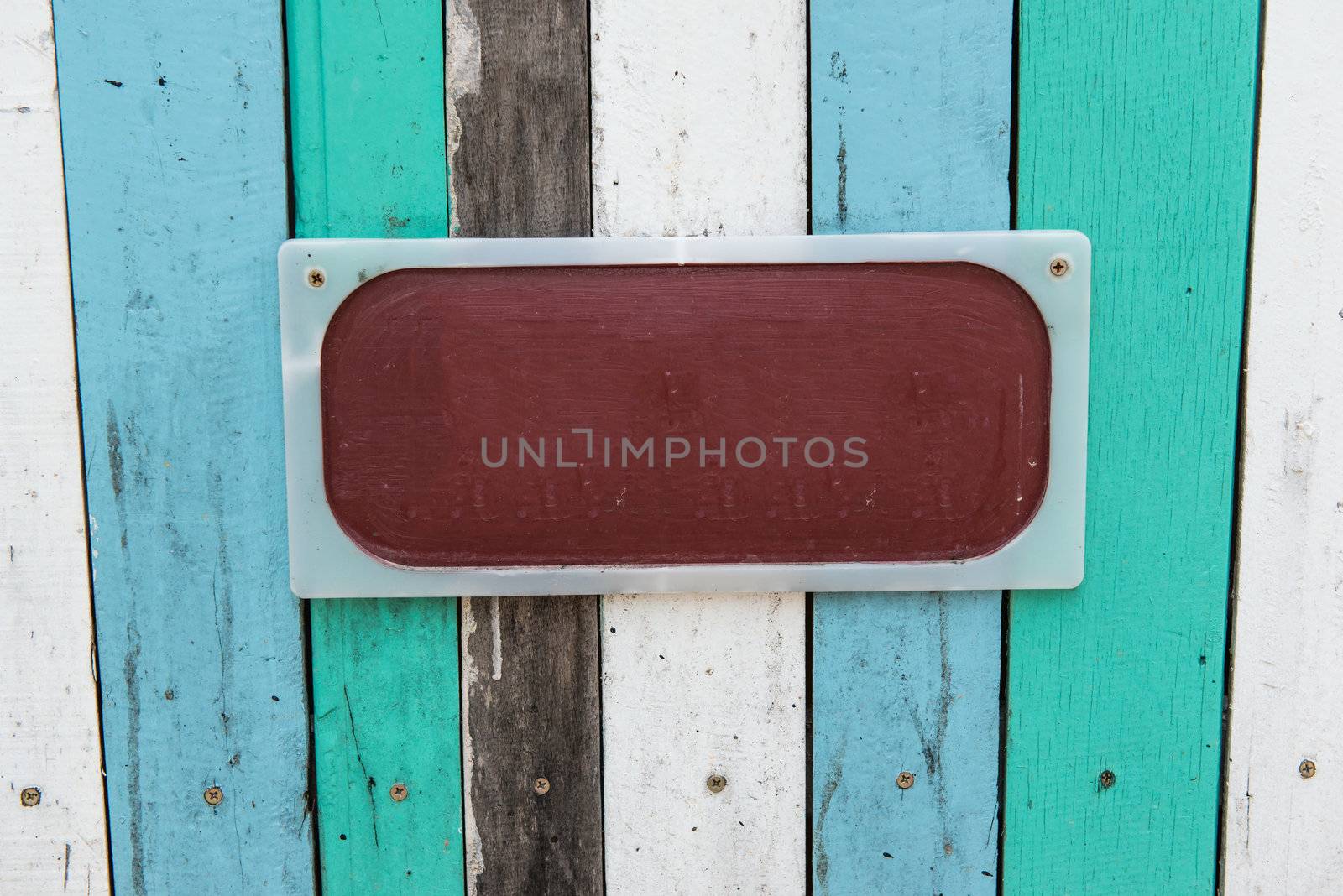 Blue, white, black contrasting old wooden texture background with metal sign, taken on a sunny day