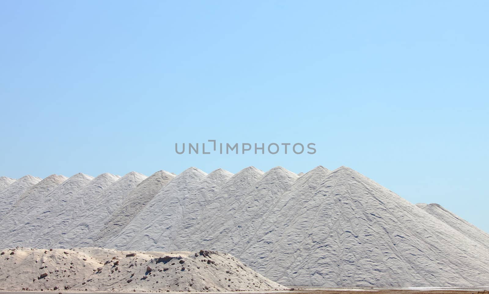 Extraction of salt. Salt mountains on blue sky.