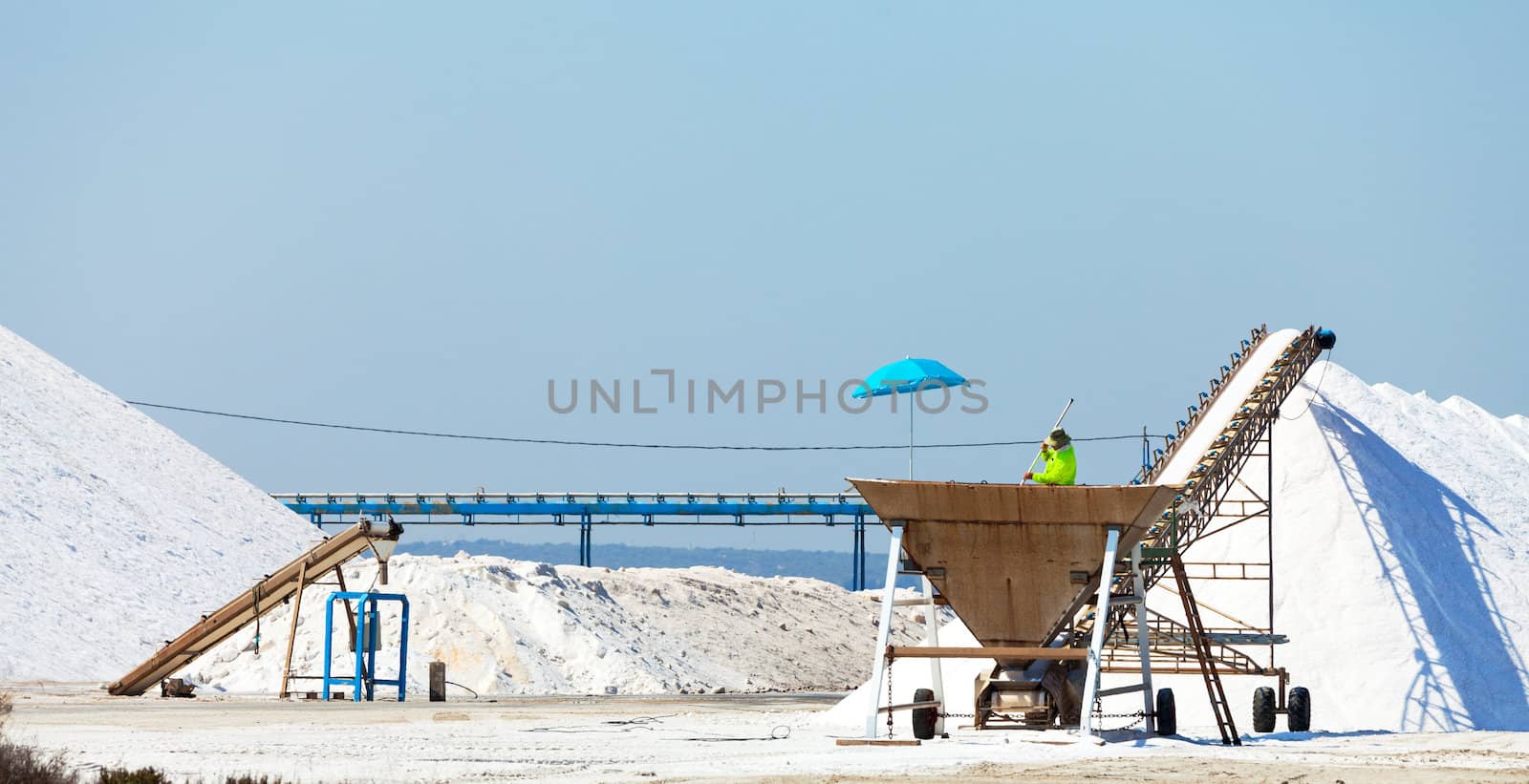 Extraction of salt. Salt mountains on blue sky.