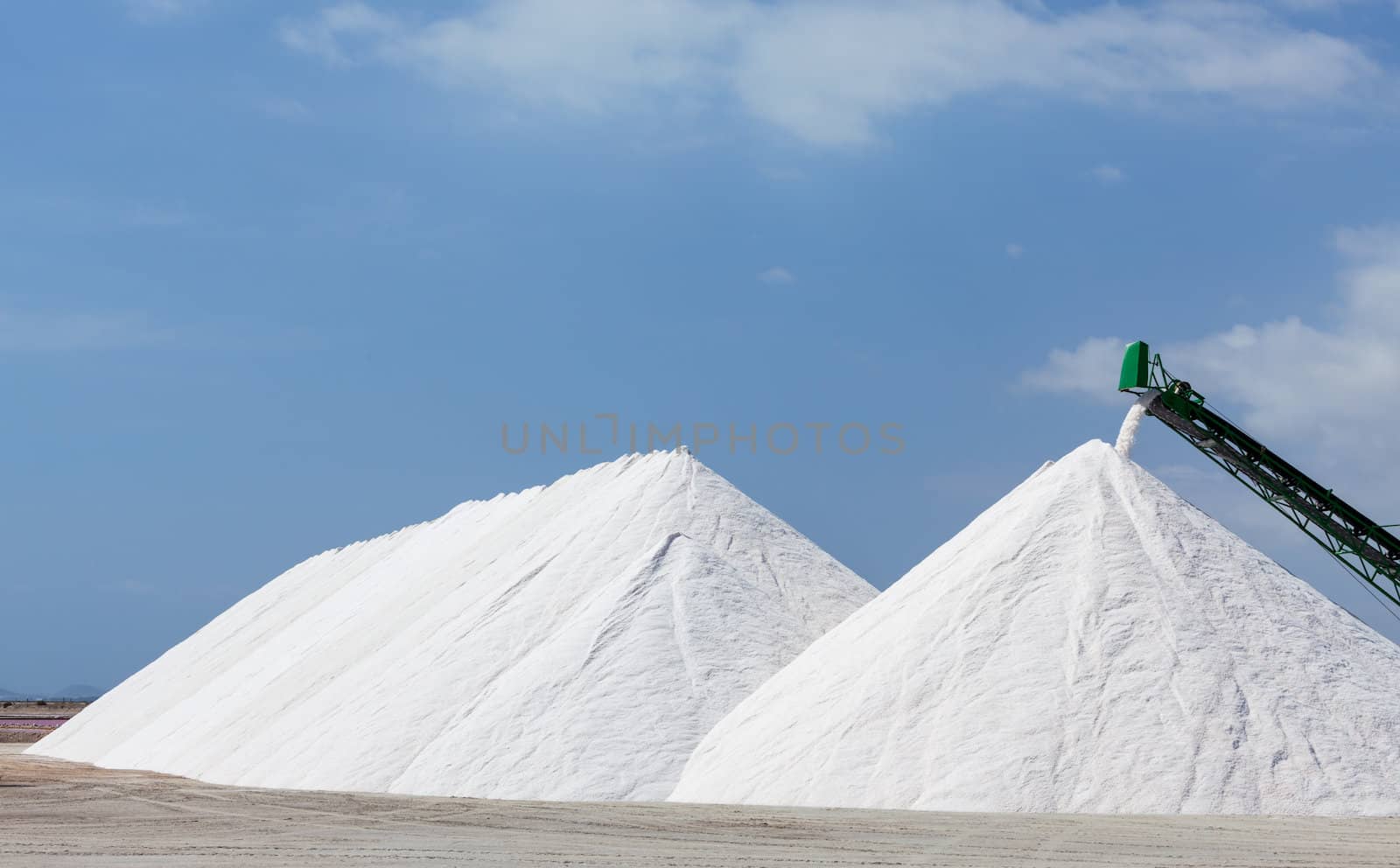 Extraction of salt. Salt mountains on blue sky.