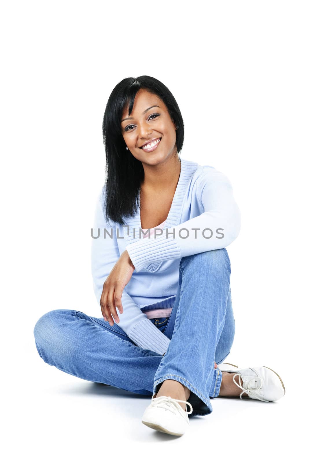 Relaxing black woman sitting on floor isolated on white background