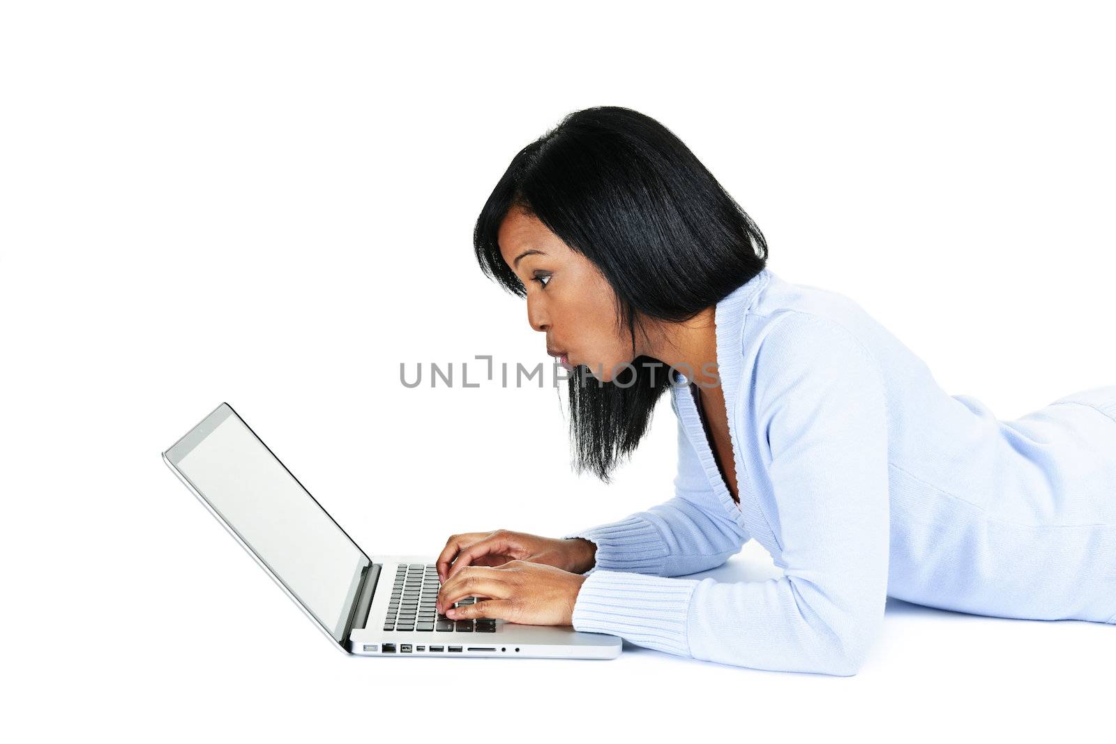 Surprised black woman laying with computer isolated on white background