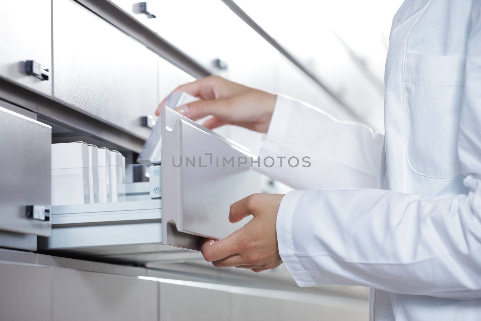 Close up view of pharmacist taking medicine from drawer