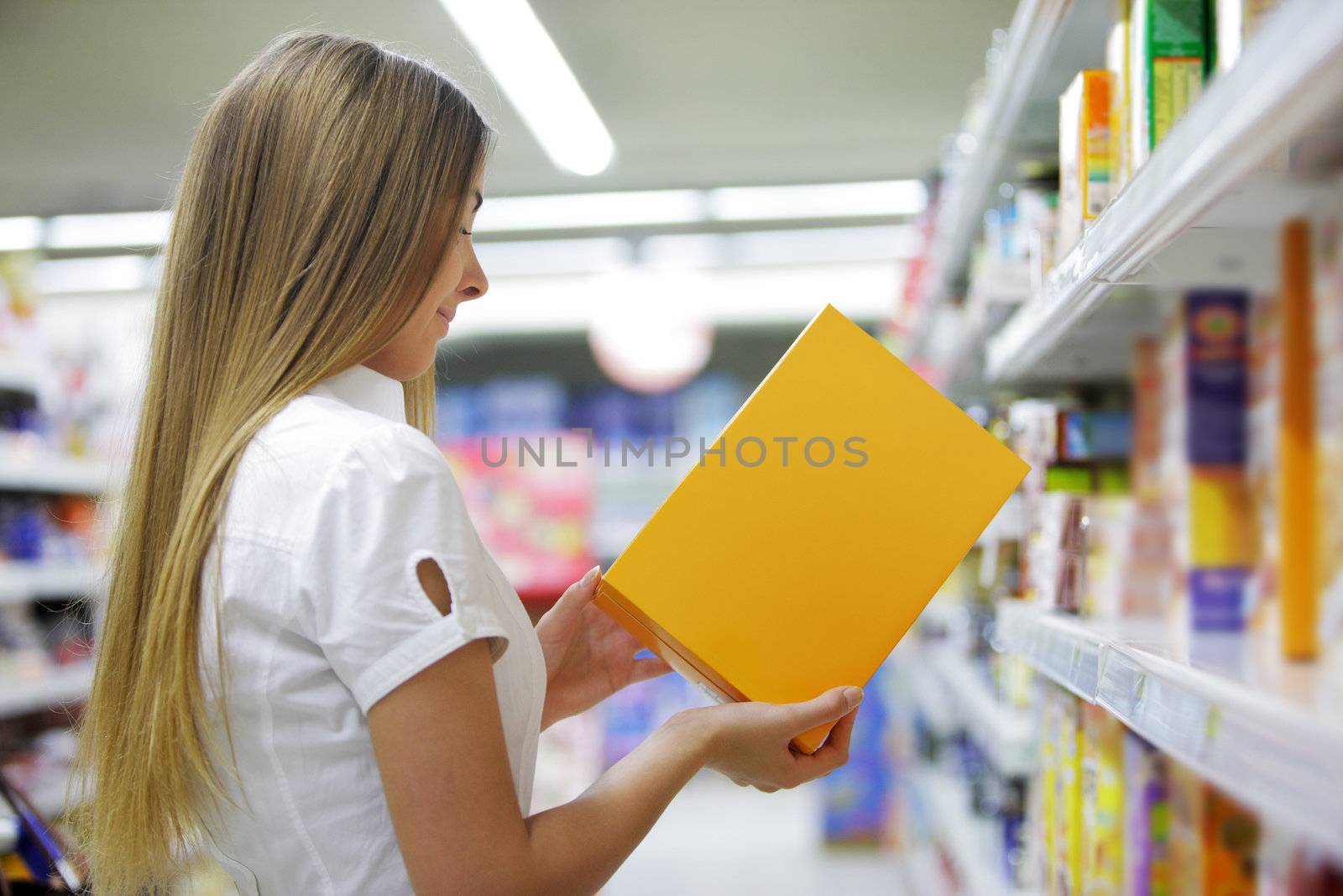 Woman checking food labelling in supermarket