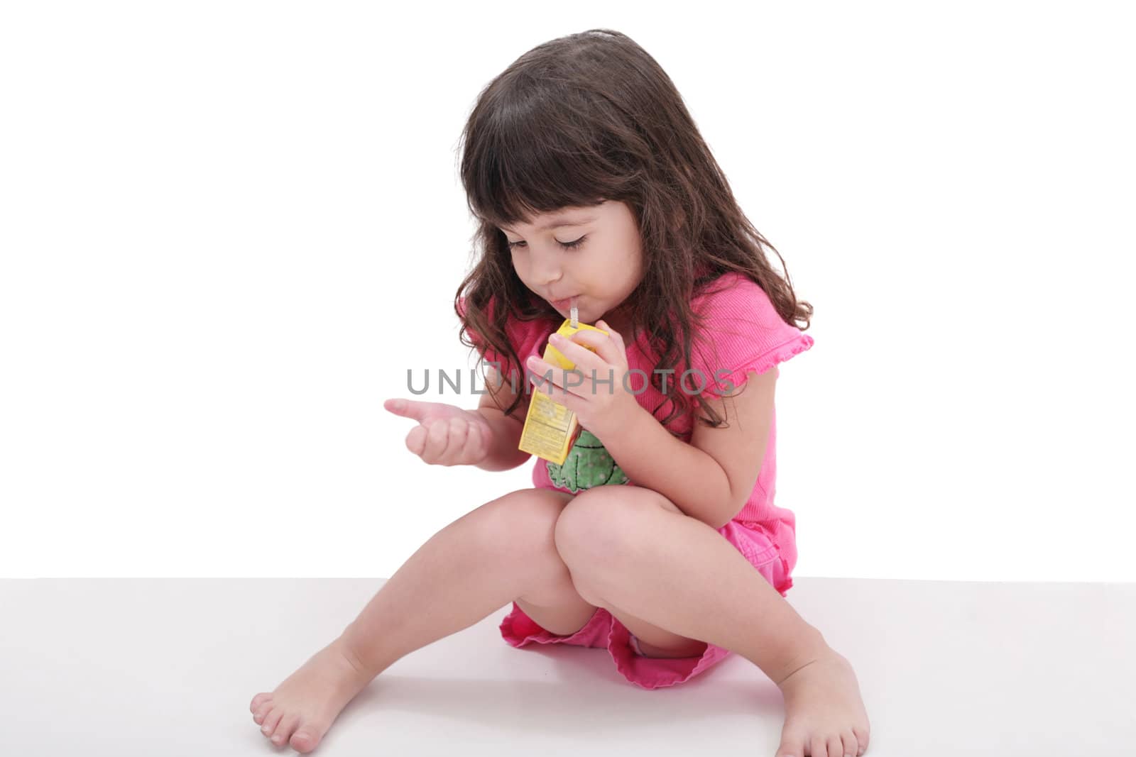 Close-up of beautiful little girl drinking from a juice box. Shot in studio over white.