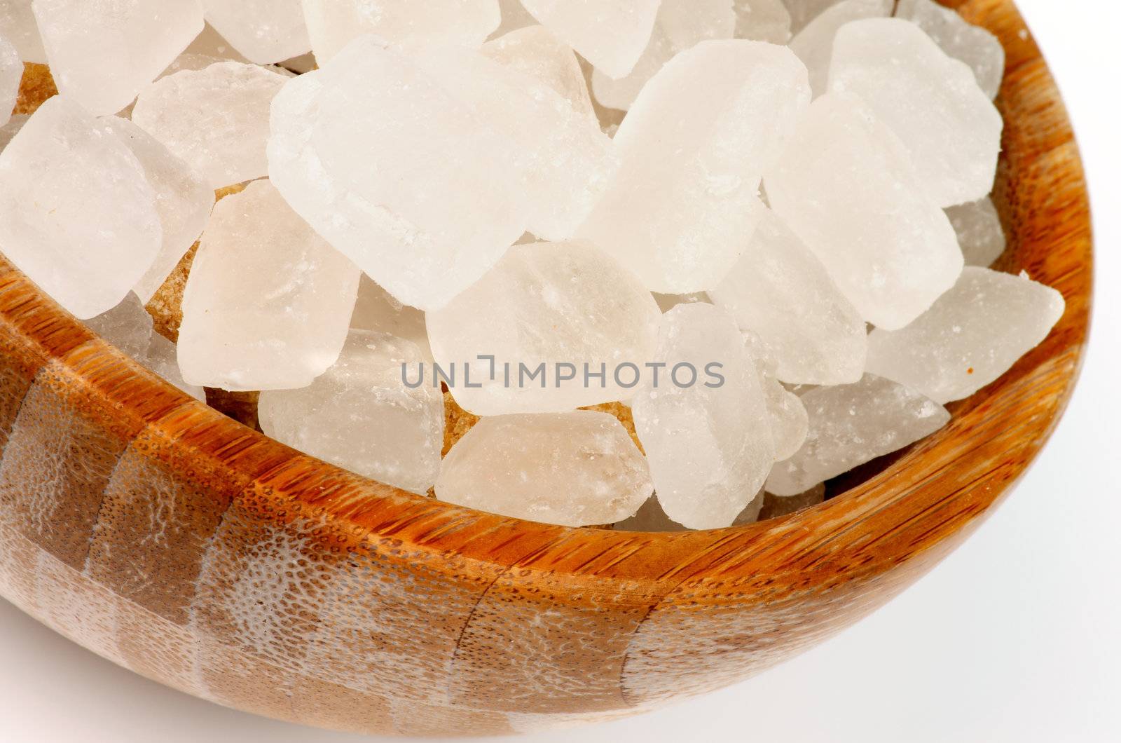 Cubes of Transparent Lemon Sugar in Wood Bowl closeup on white background