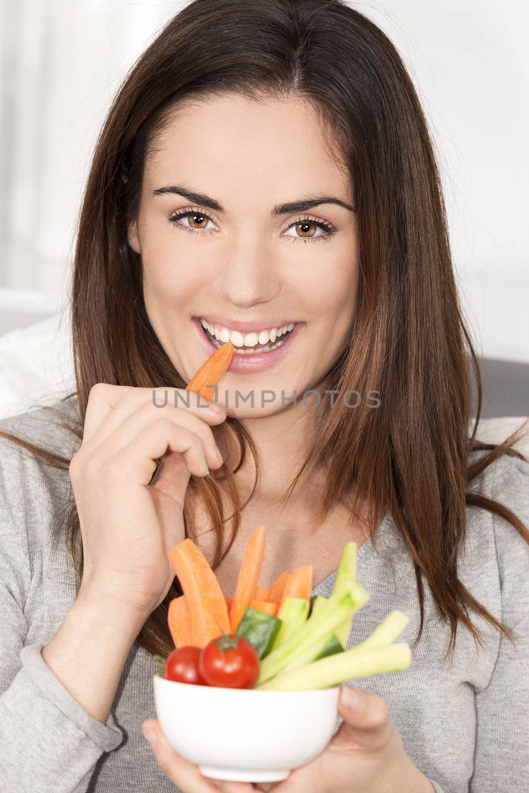 woman on sofa eating vegetable salad by vwalakte