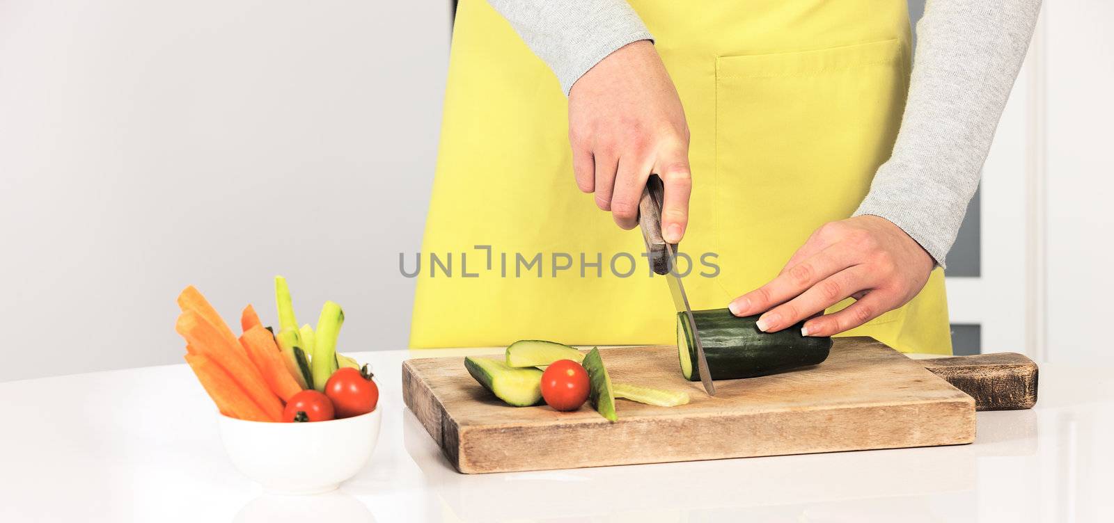 Woman cutting cucumber by vwalakte