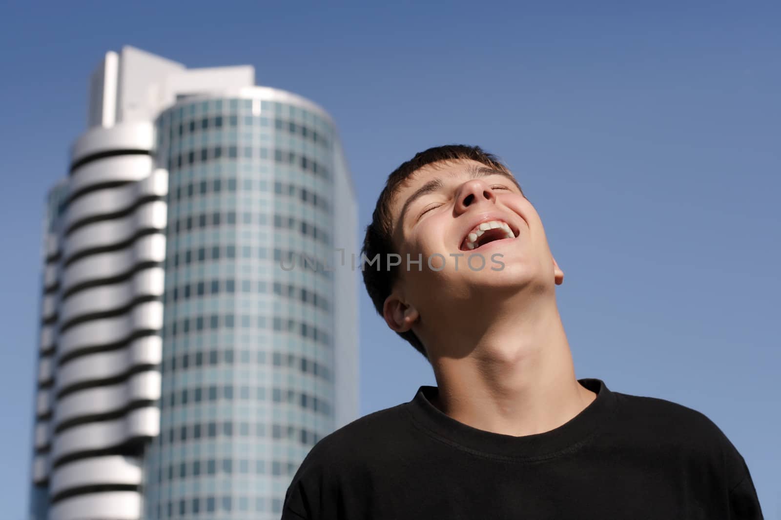 Happy Teenager on the glass building and blue sky background