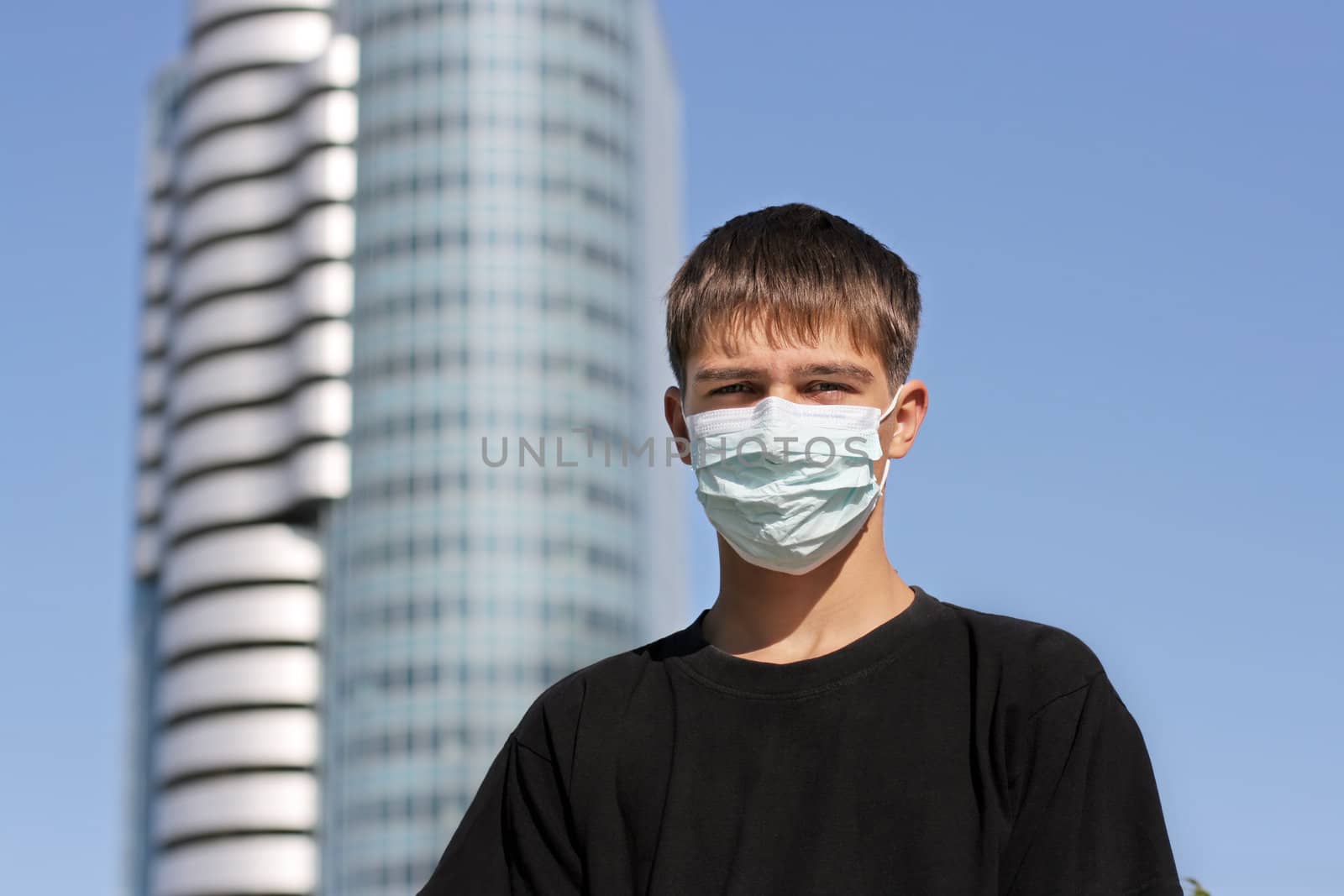 Serious Teenager in the Flu Mask on the City Street