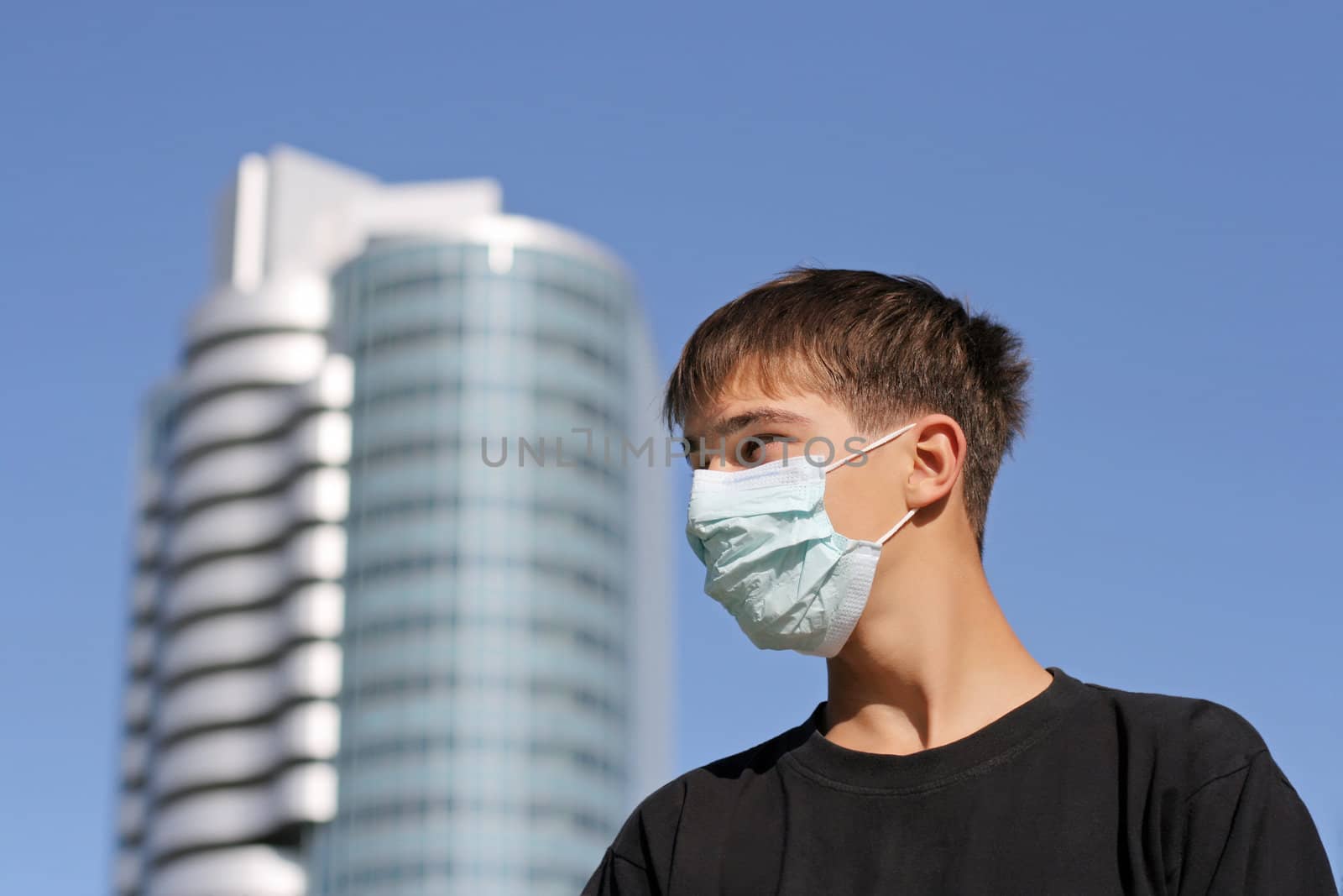 Serious Teenager in the Flu Mask on the City Street