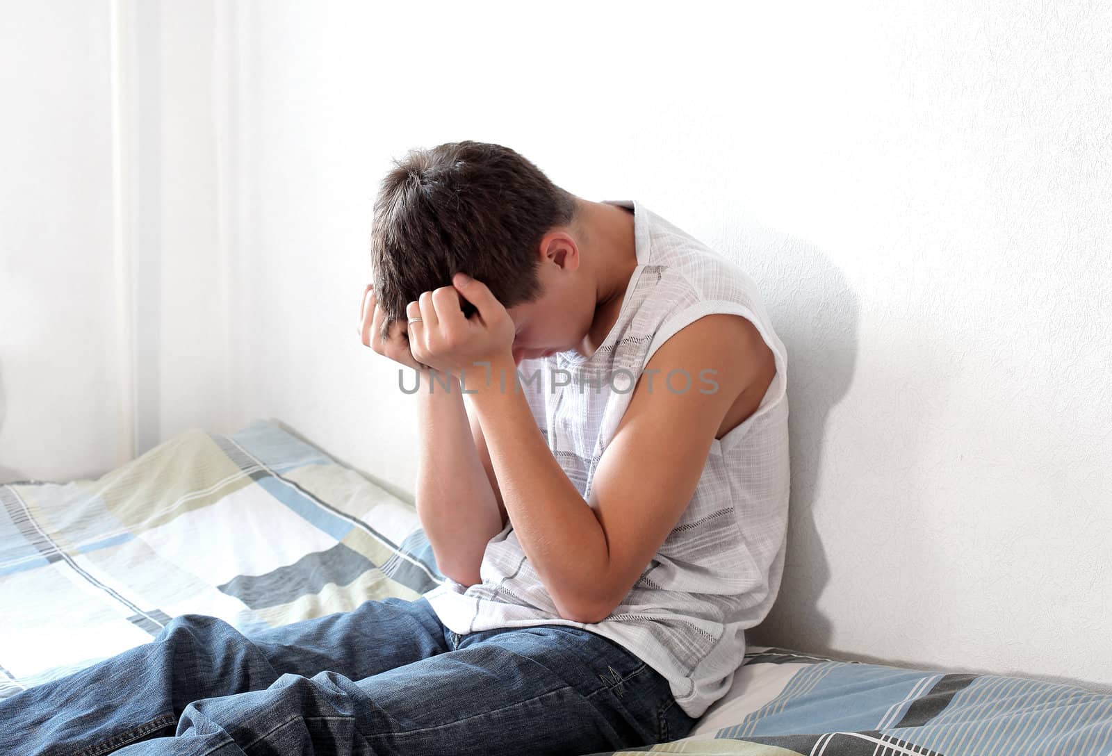 Sad Teenager sitting on the Bed in Home interior