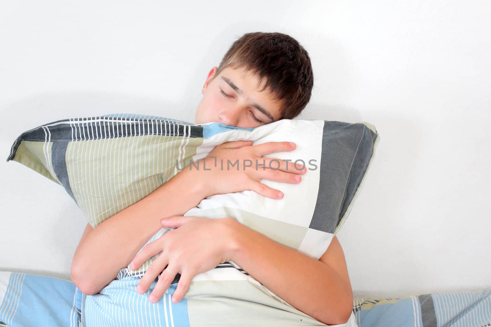 Sad Teenager sitting with pillow on the Bed in Home interior