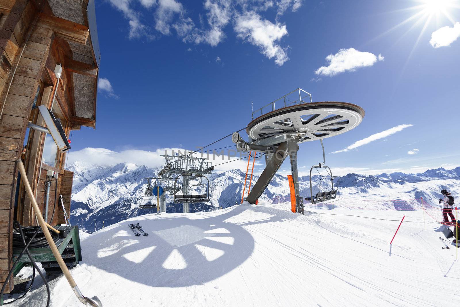 Ski chair-lift arrival in alpine mountain with sun, France