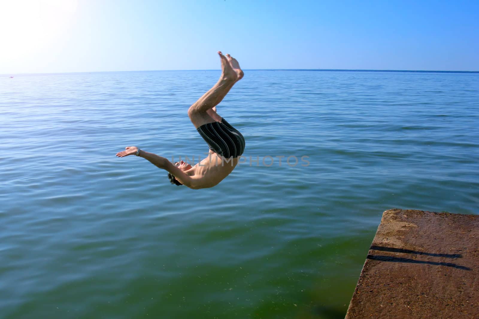 The man make a trick and jumps in the sea