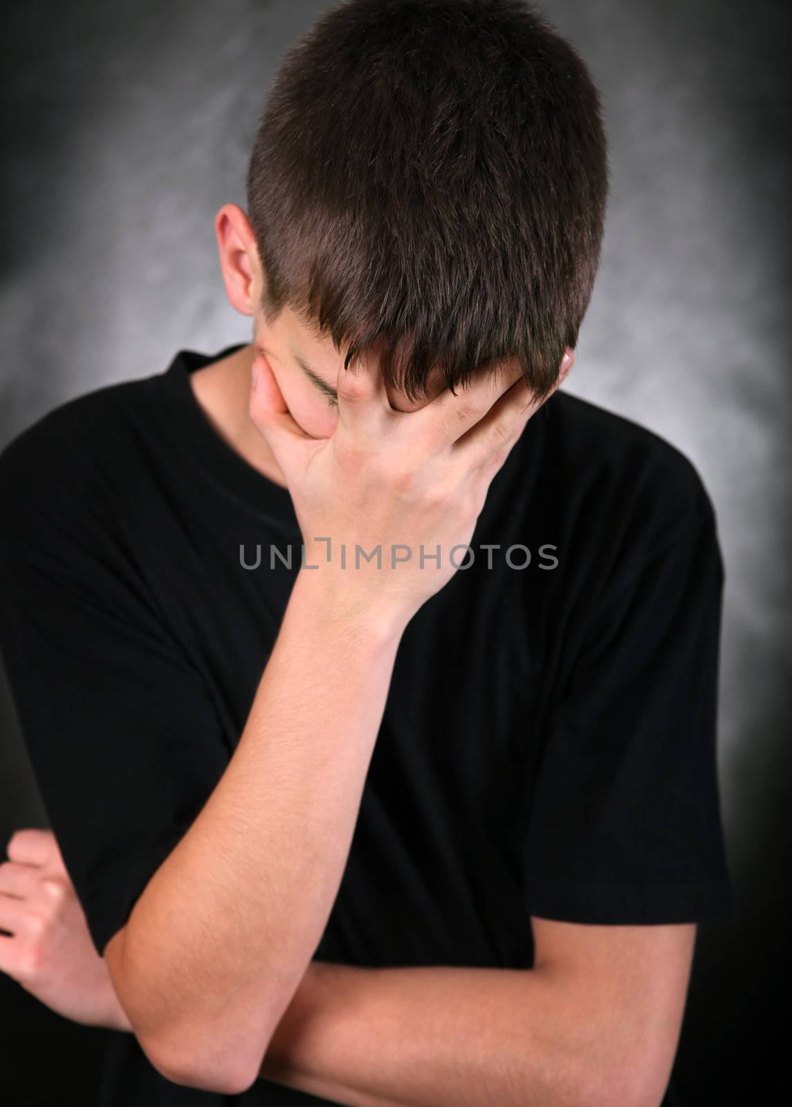 Sad Young Man On the Black Background hide his Face