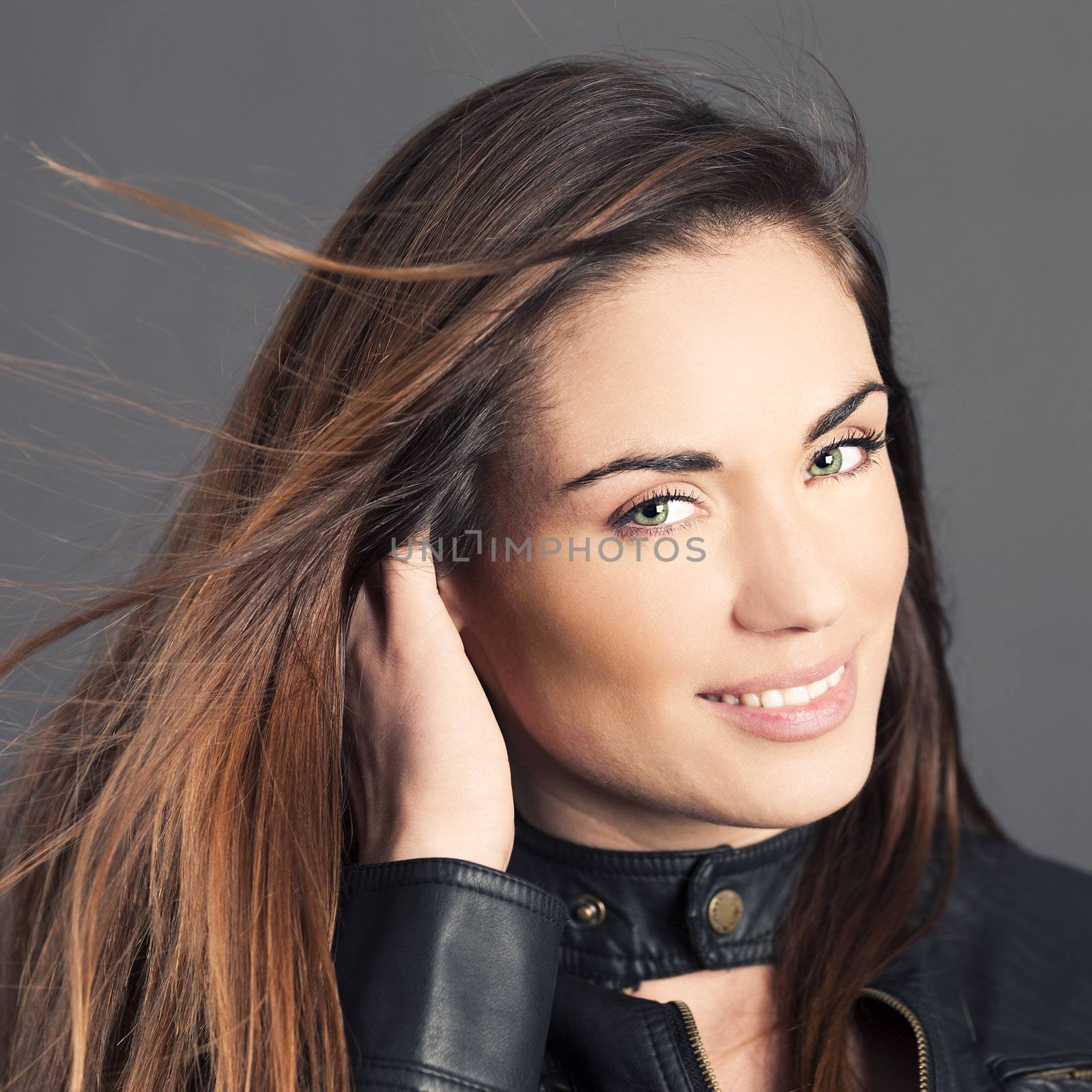 Portrait of beautiful woman model with hand in hair