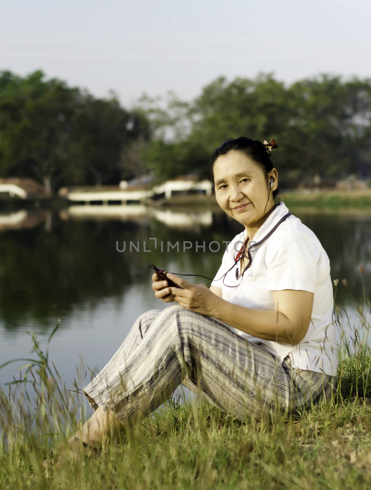 Happy woman listening to music outdoors  by siraanamwong