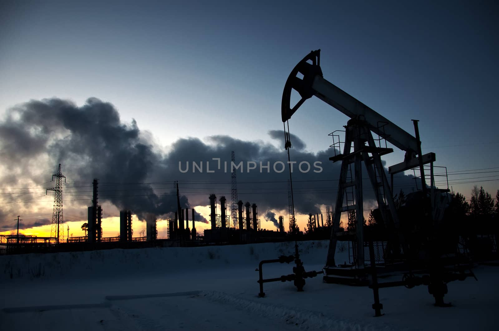 oil pump on  background of  industrial landscape and winter sky in  smoke
