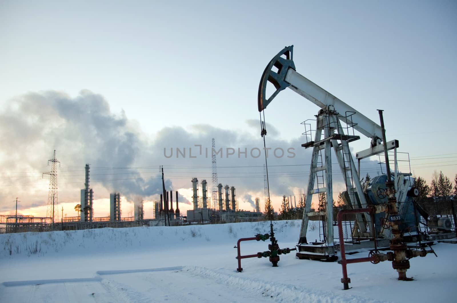 oil pump on  background of  industrial landscape and winter sky in  smoke