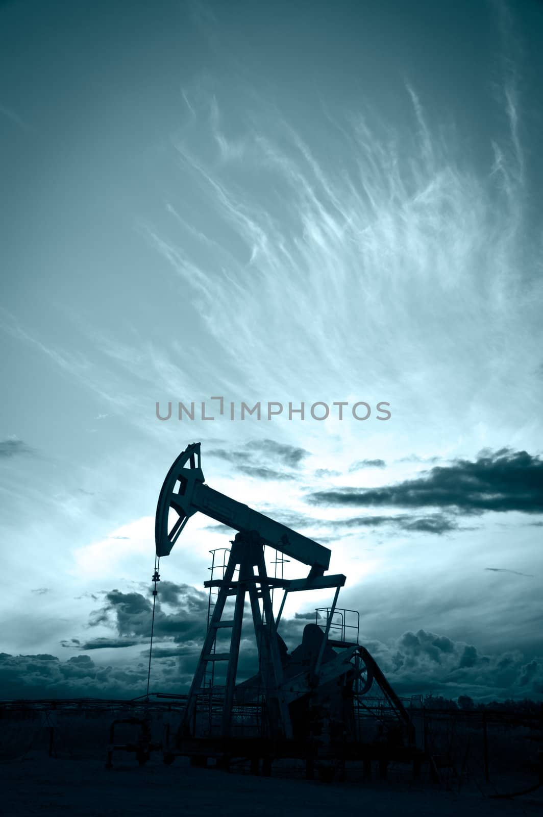 Oil and gas industry. Silhouette oil pump on a sunset sky background. Toned.