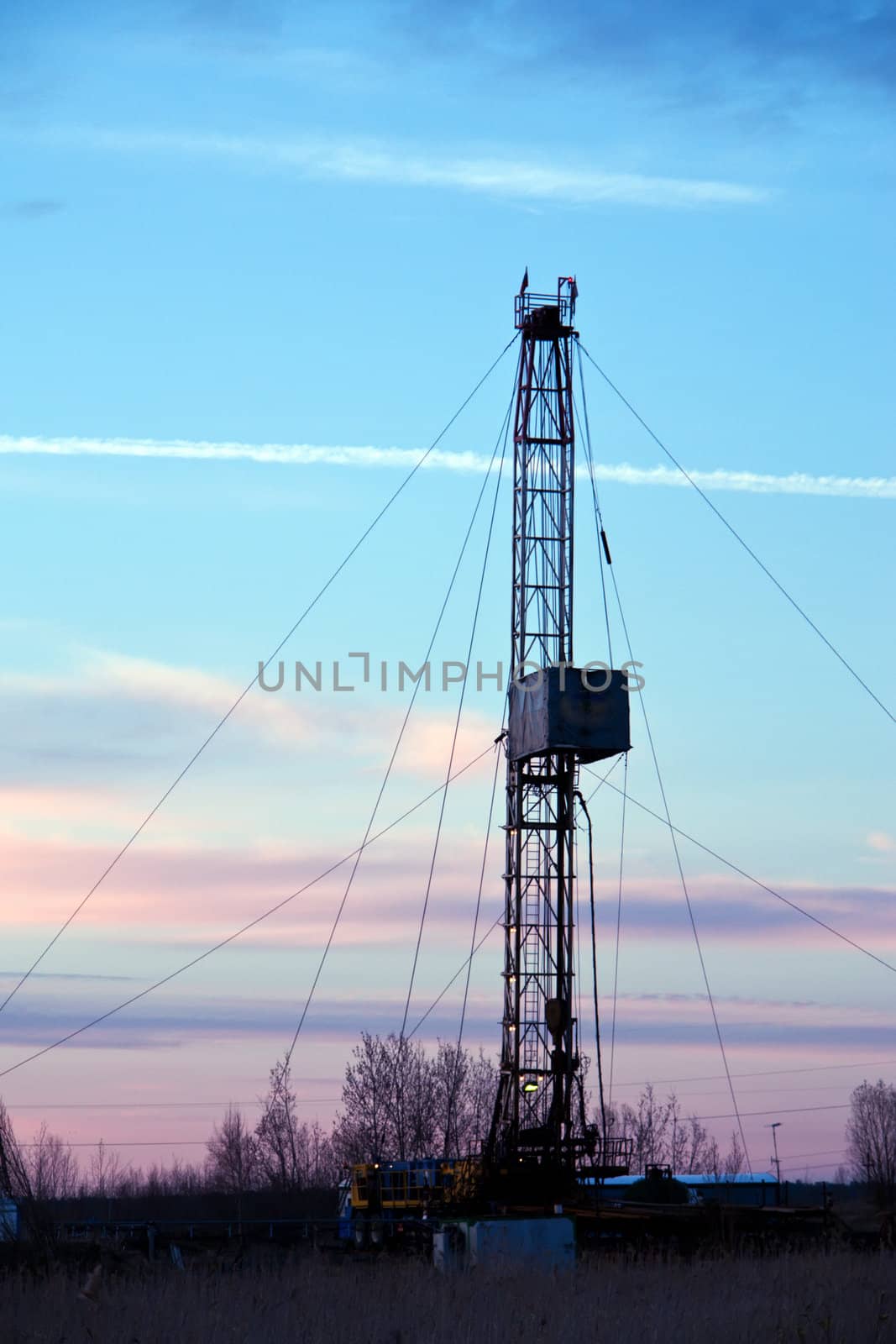 Vertical view of a drilling rig on a sunset background