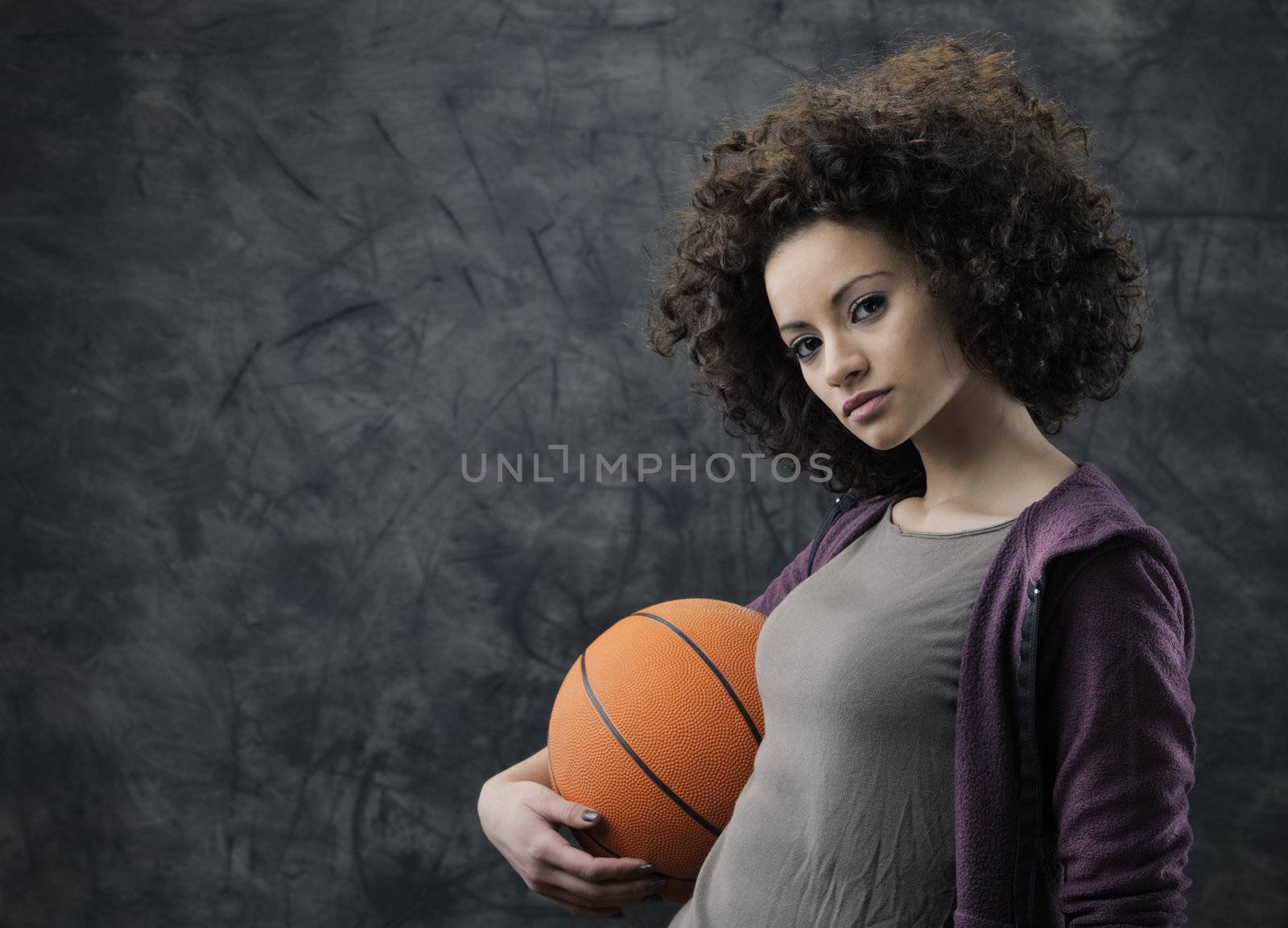 Portrait of young beautiful woman holding a basketball