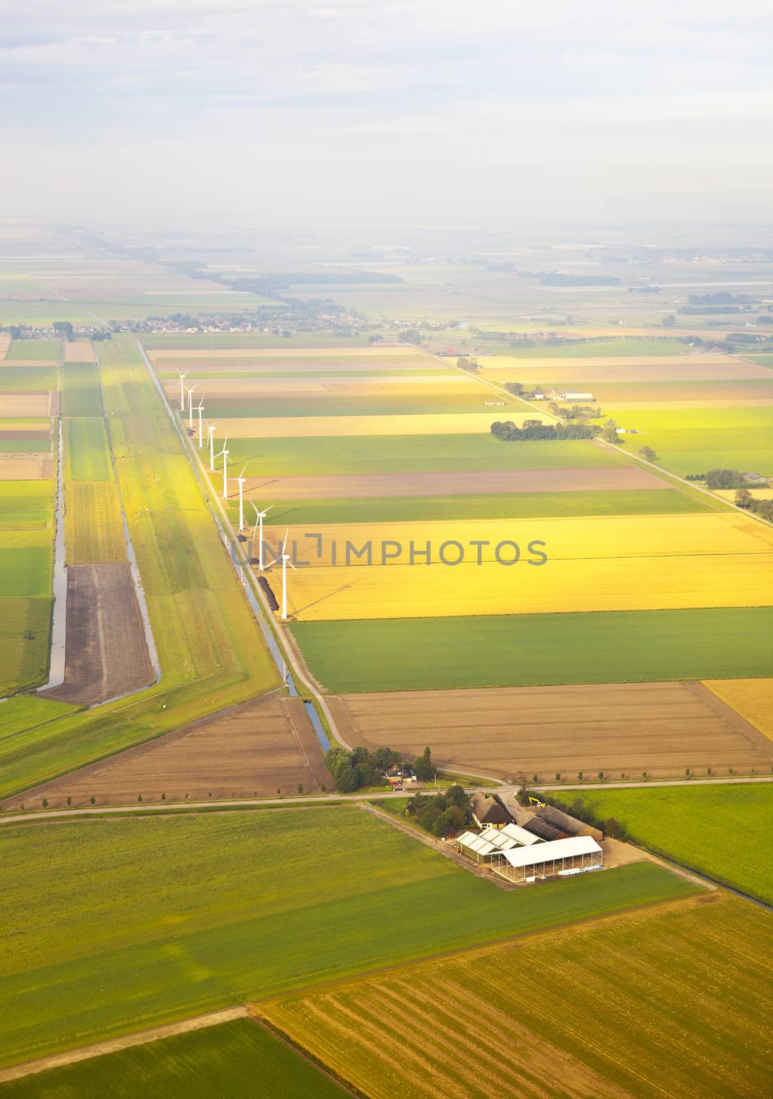Several windmills and farm at Dutch landscape from above