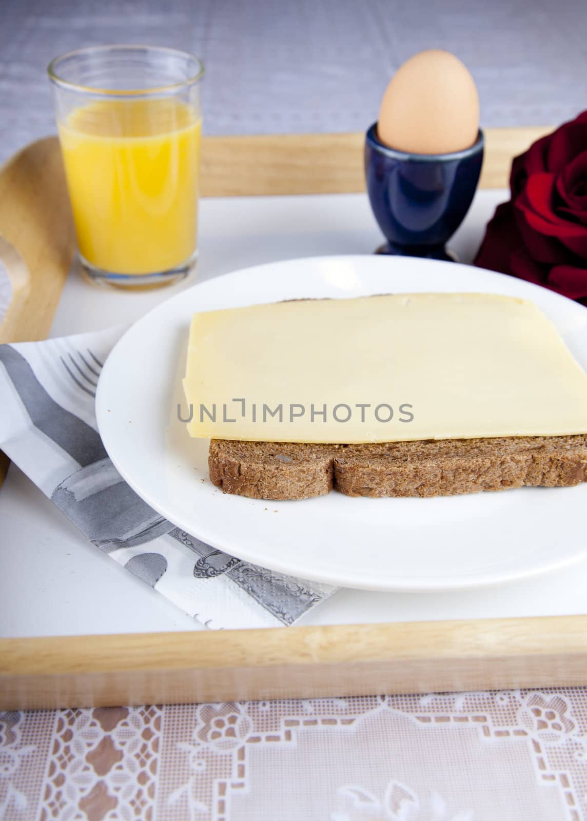 Breakfast on plate with bread, cheese, egg and orange jus