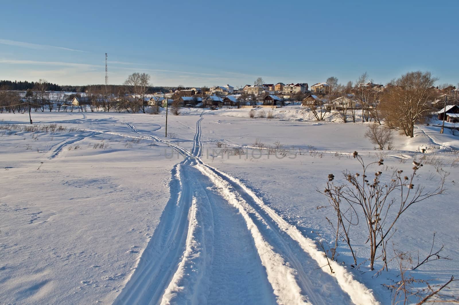 Snowmobile trail through a field of snow, sunset