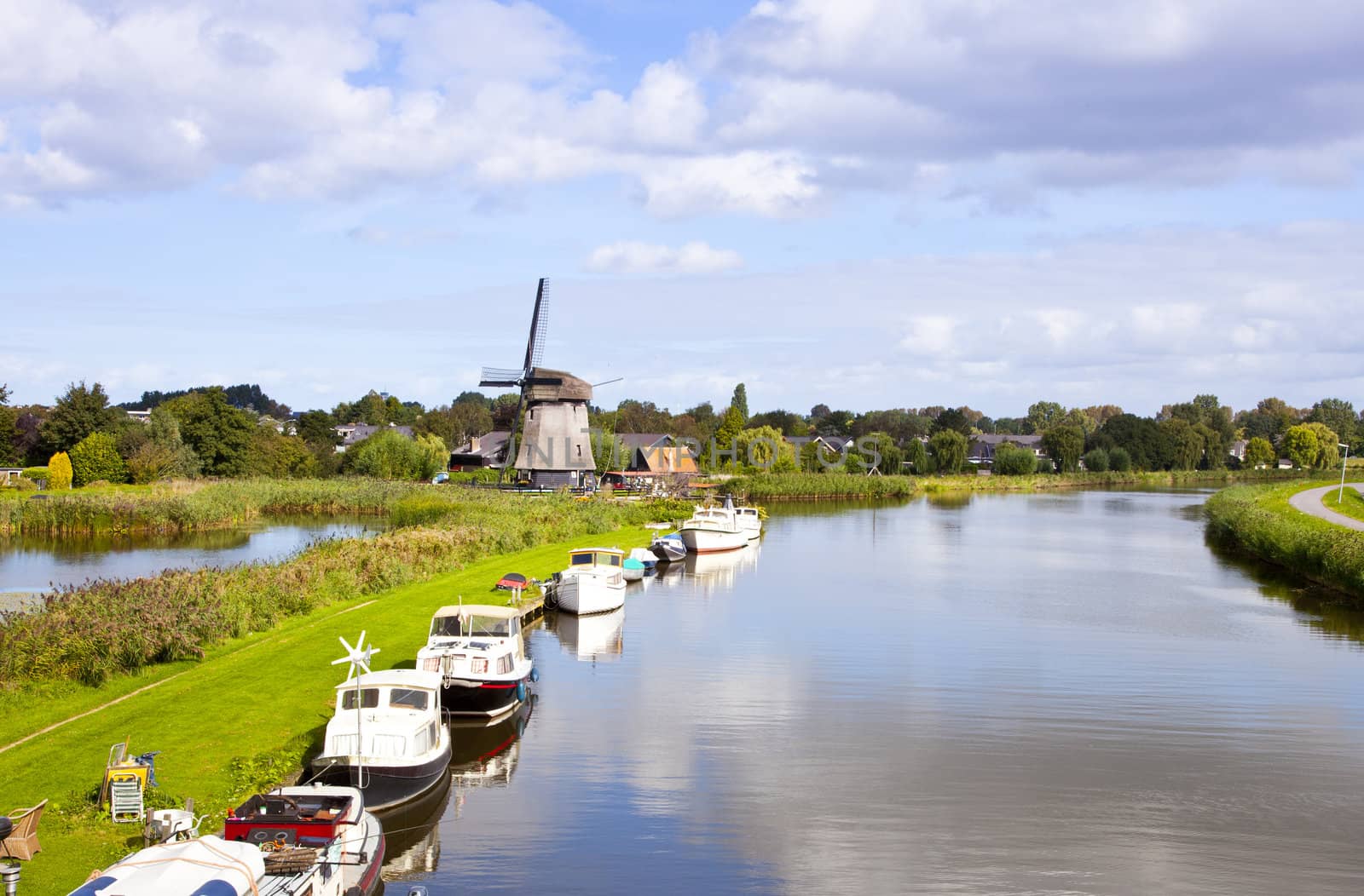 Dutch wind mill at river with little boats