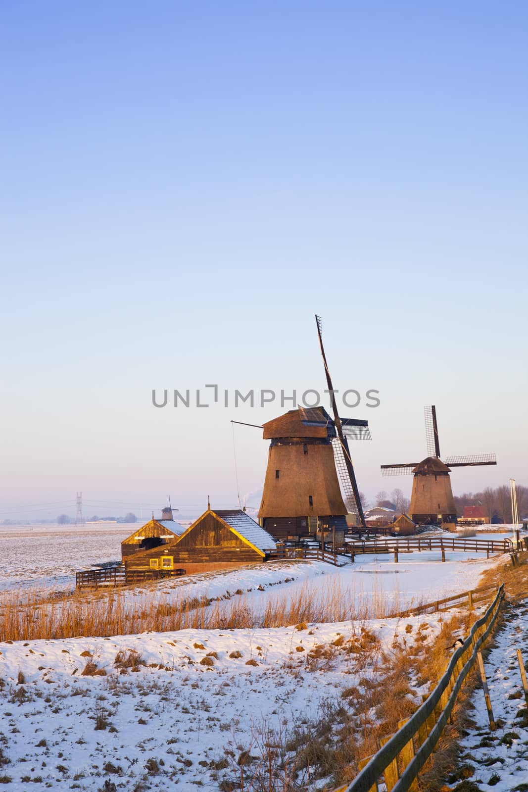 Windmill in winter time with snow and blue sky