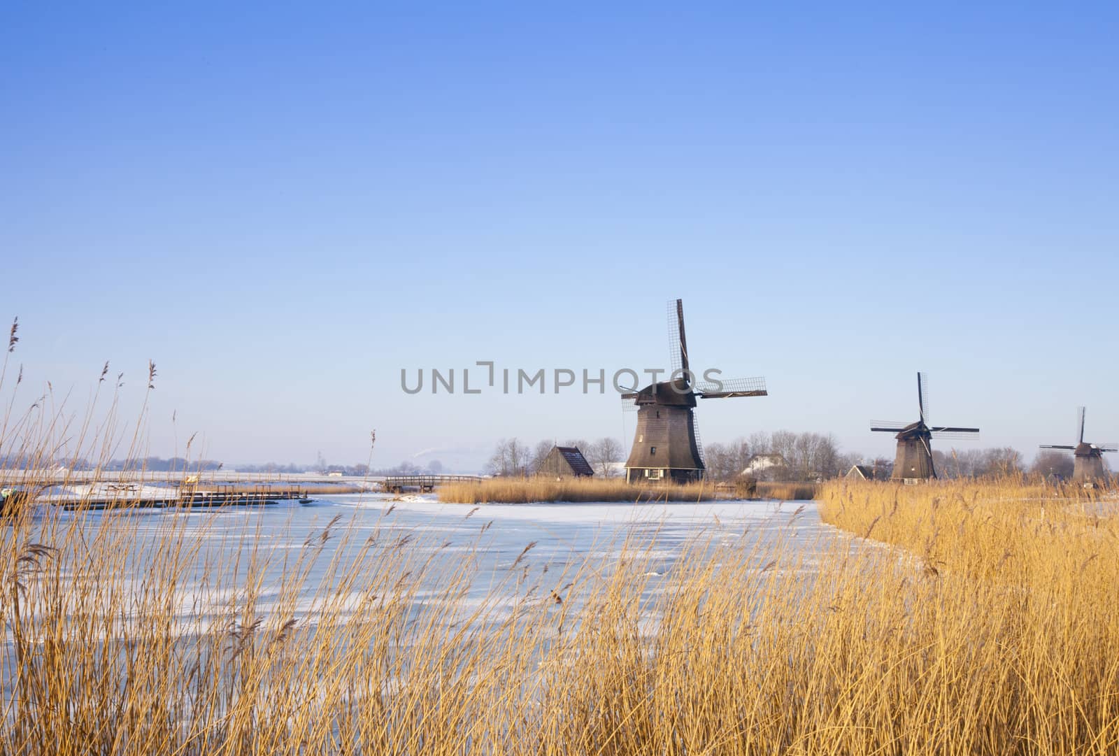 Windmill in winter time with snow and blue sky