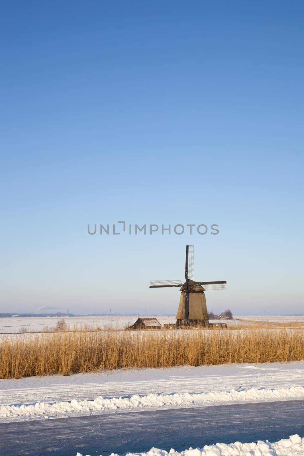 Windmill in winter time with snow,ice and blue sky