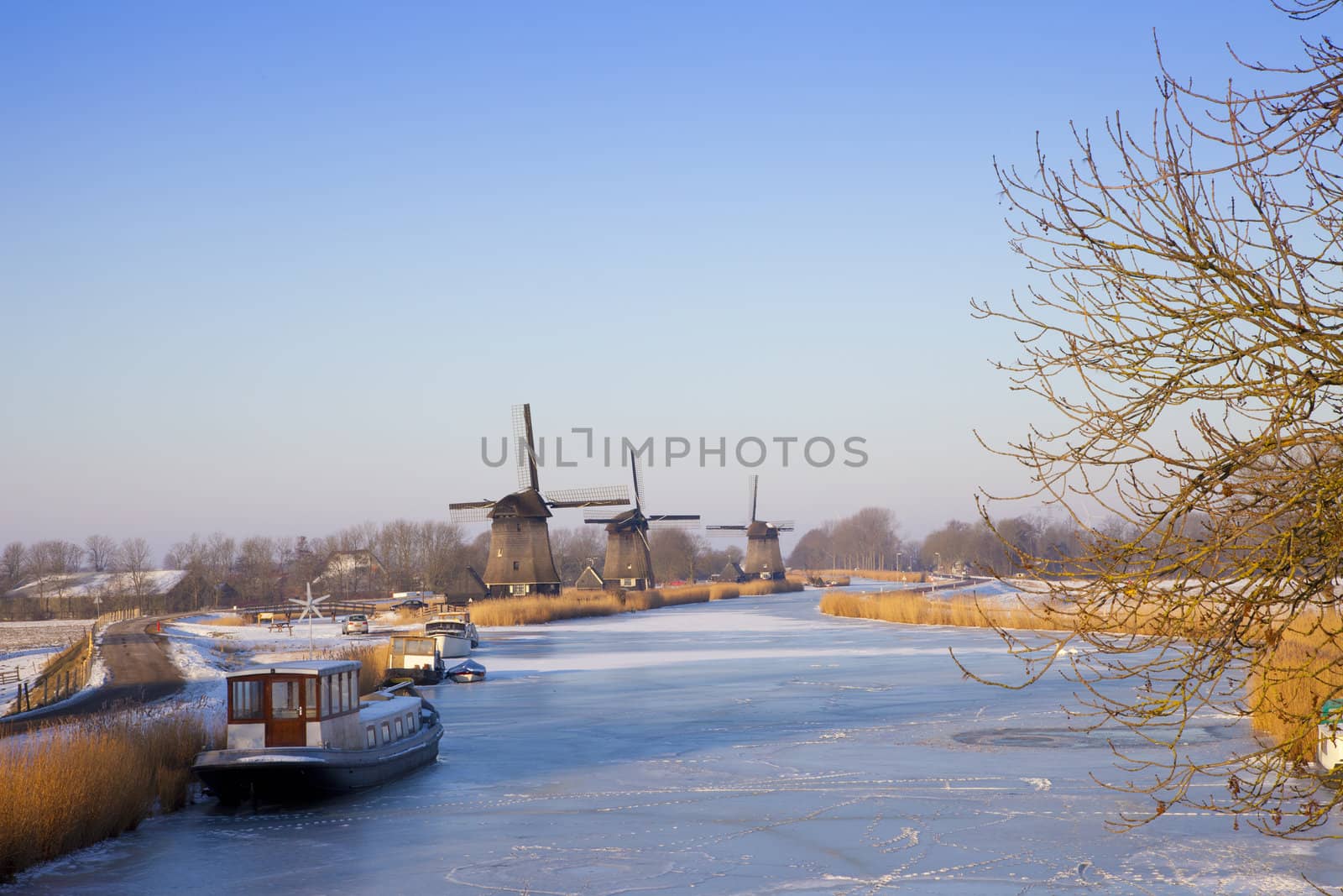 Windmill in winter time with snow and blue sky