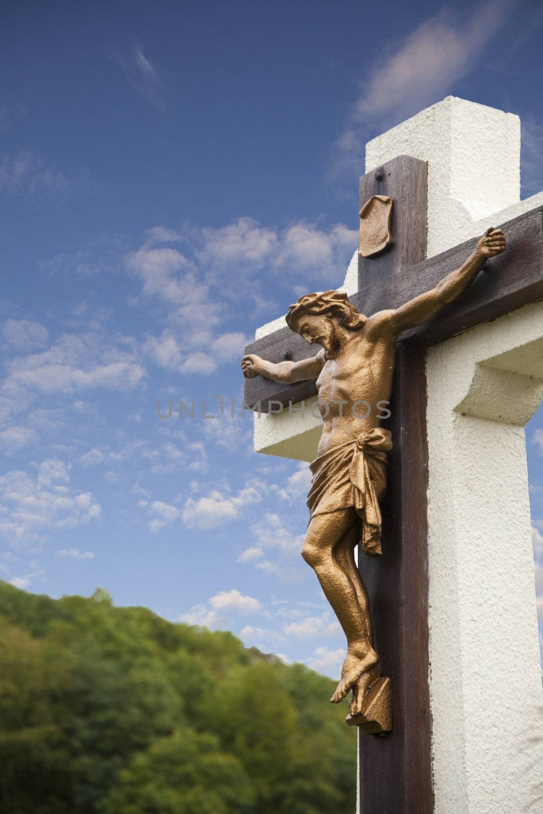 Statue of Jesus on cross with blue sky