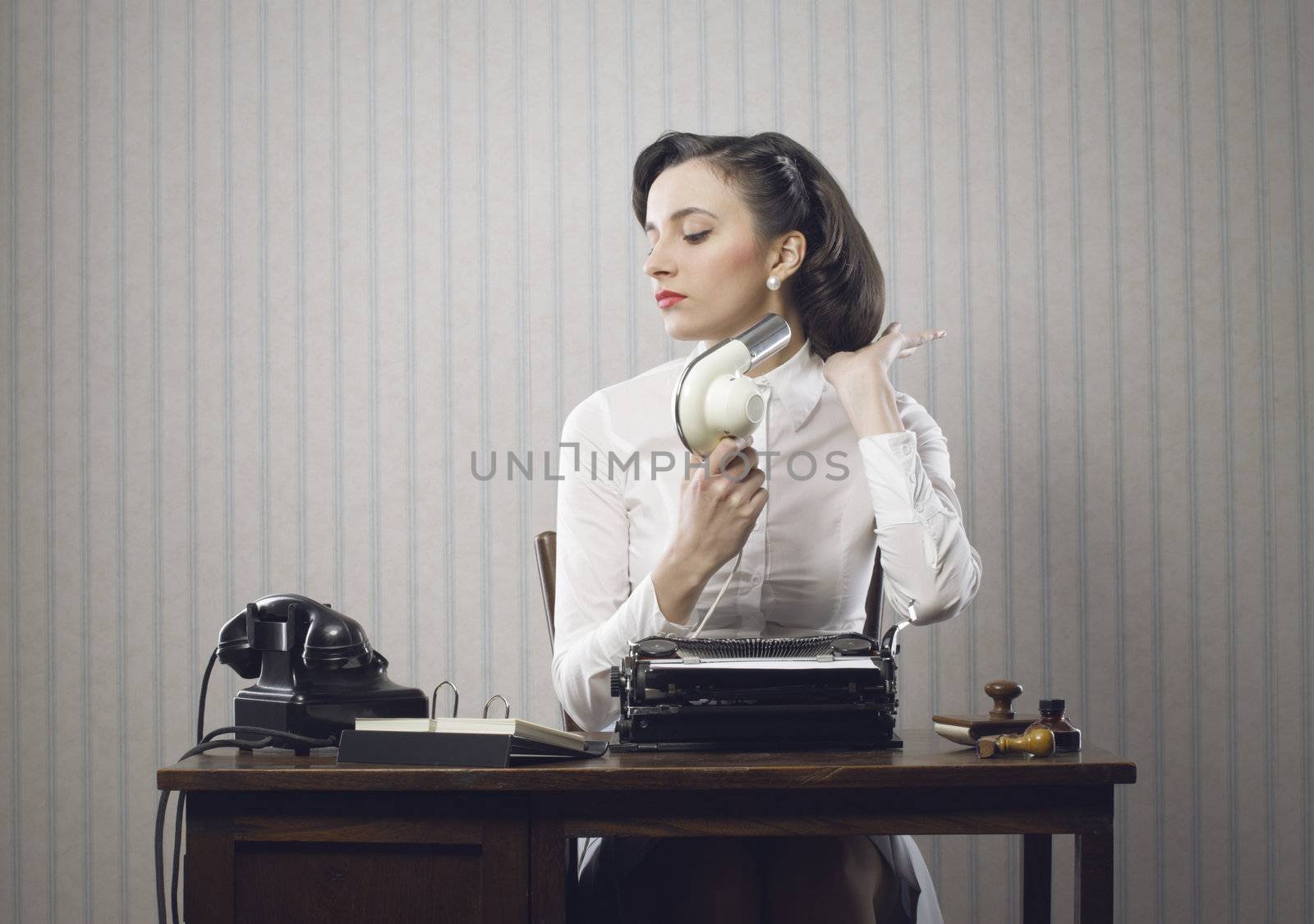 Business woman drying her hair in office