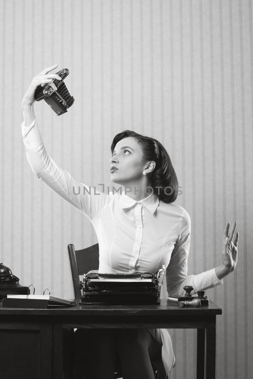 Beautiful business woman taking a picture of herself with a old camera