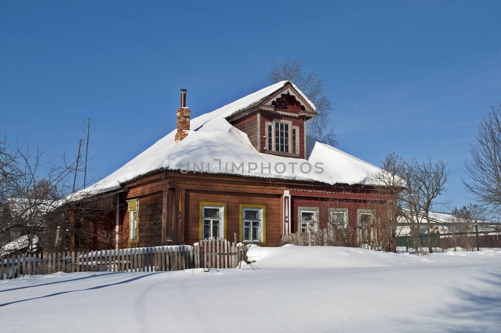 Old wooden house in snow, winter sunny day