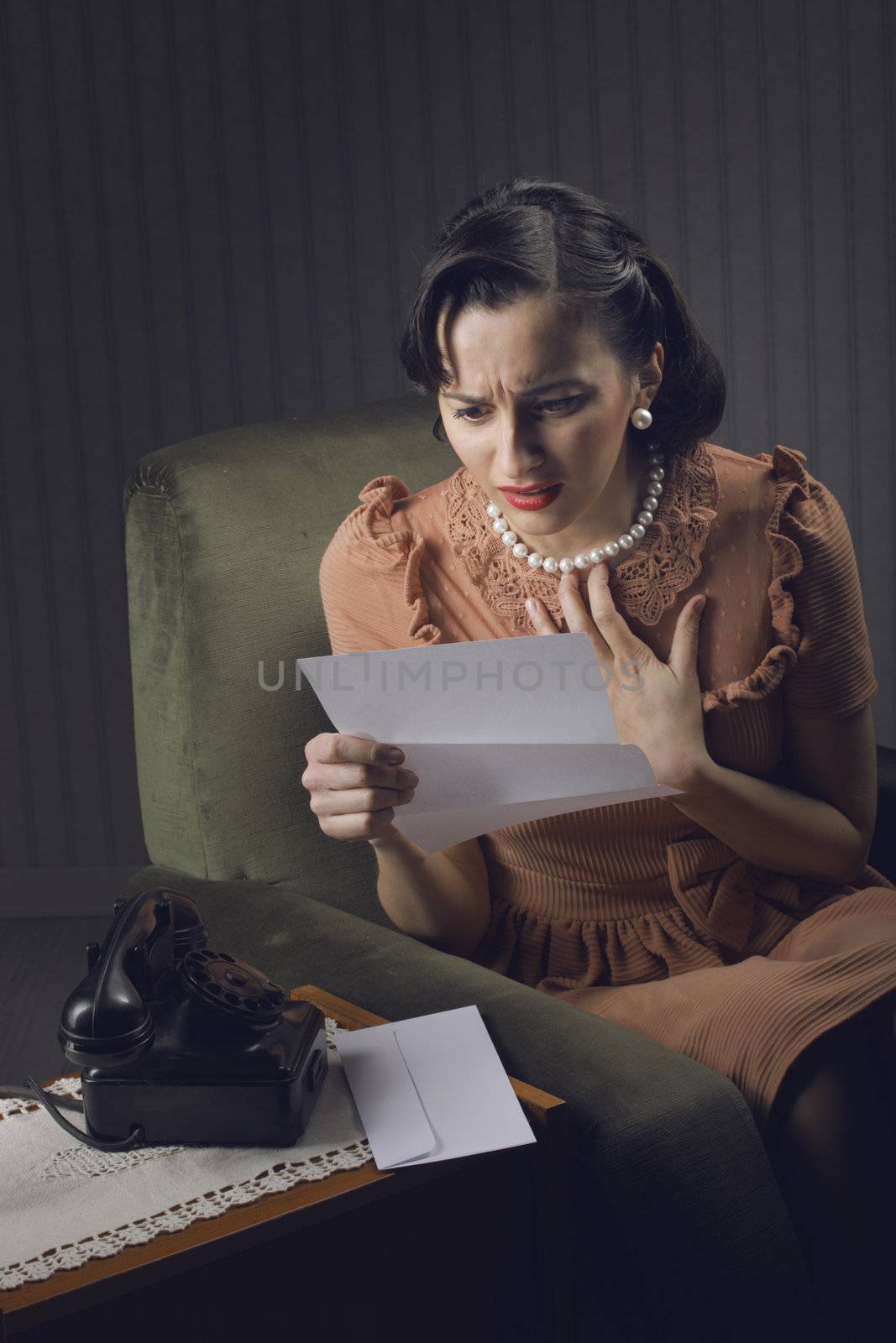 Young woman reading a letter with worried expression