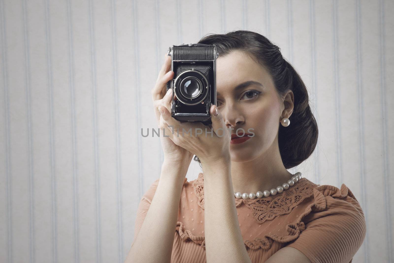 Beautiful young woman with a old camera