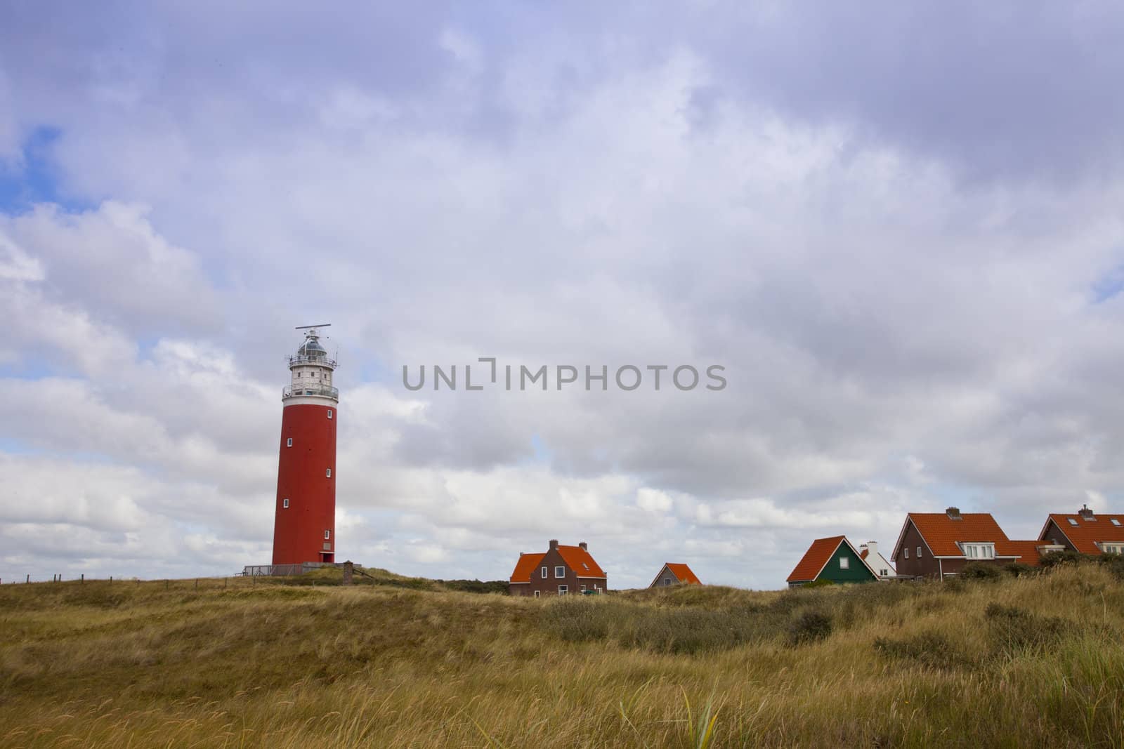 Red lighthouse and houses on island Texel, The Netherlands