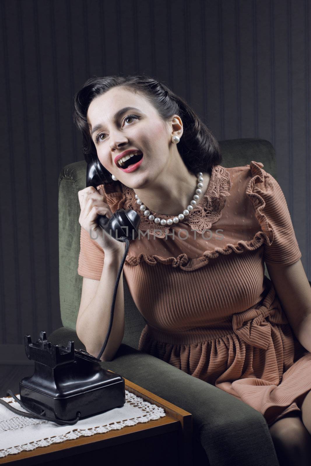 Happy woman talking on landline phone