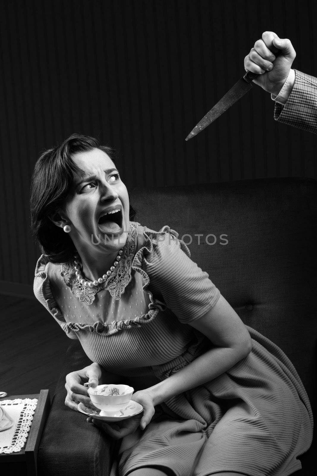 Terrified woman by a man murderess with a knife. Classic film noir style