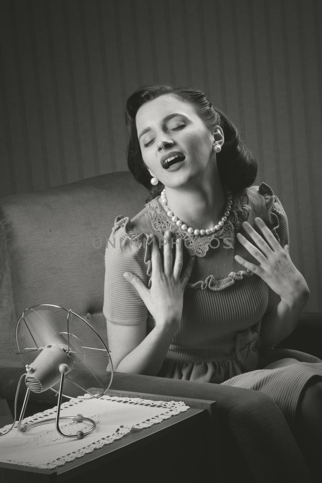 Beautiful woman using a fan to cool off