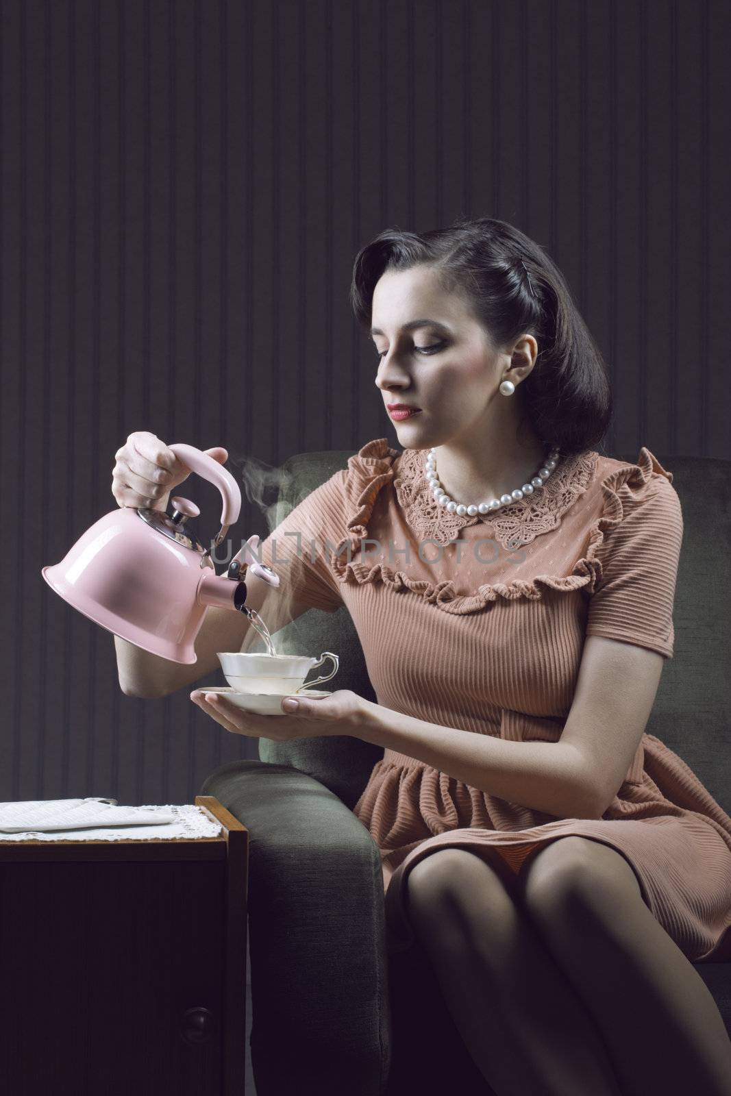 Beautiful woman sitting at armchair, drinking tea 