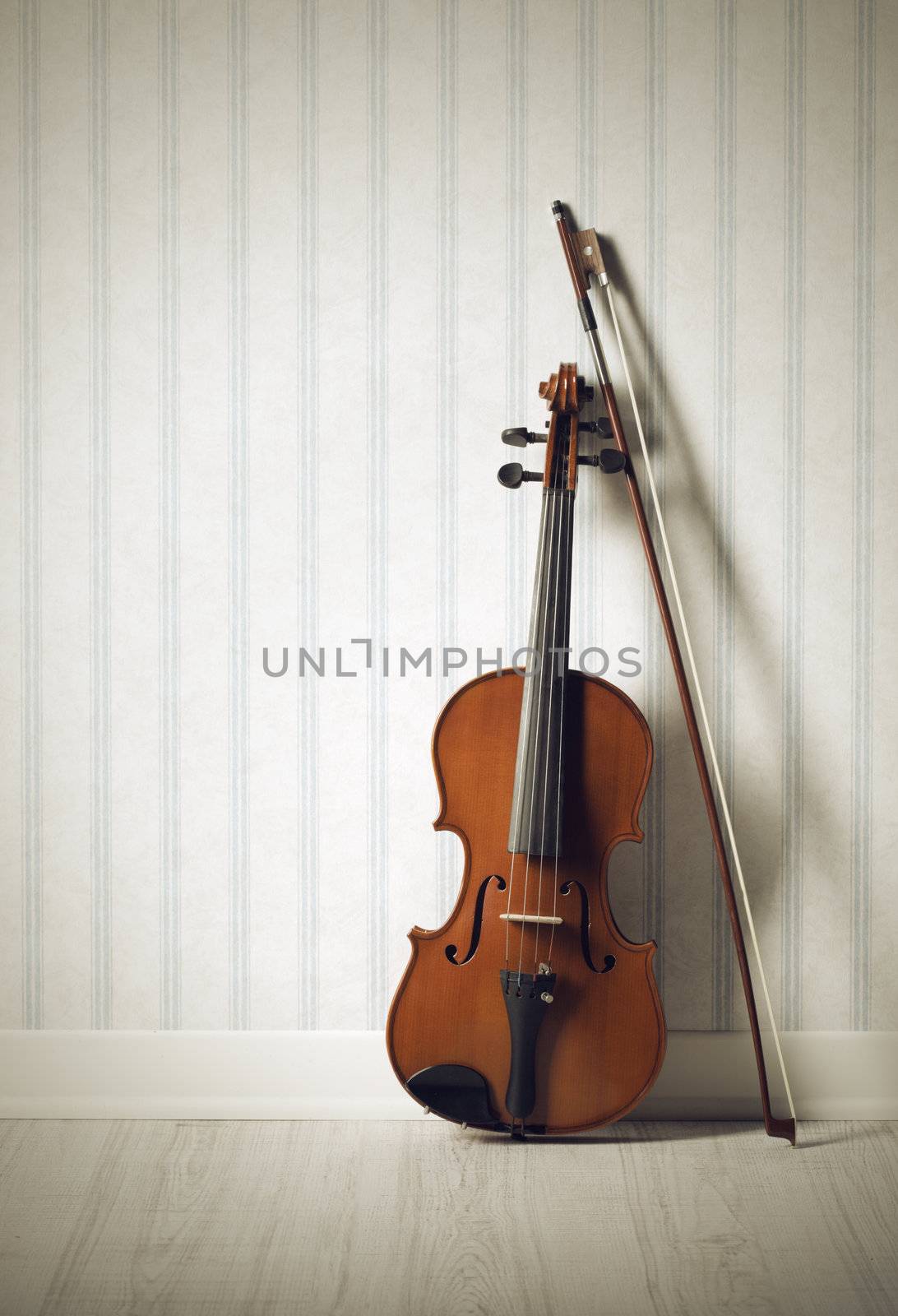 Violin and bow on a vintage wallpaper