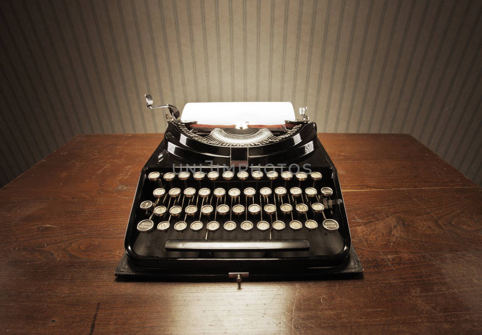 Old typewriter on a wooden desk by stokkete
