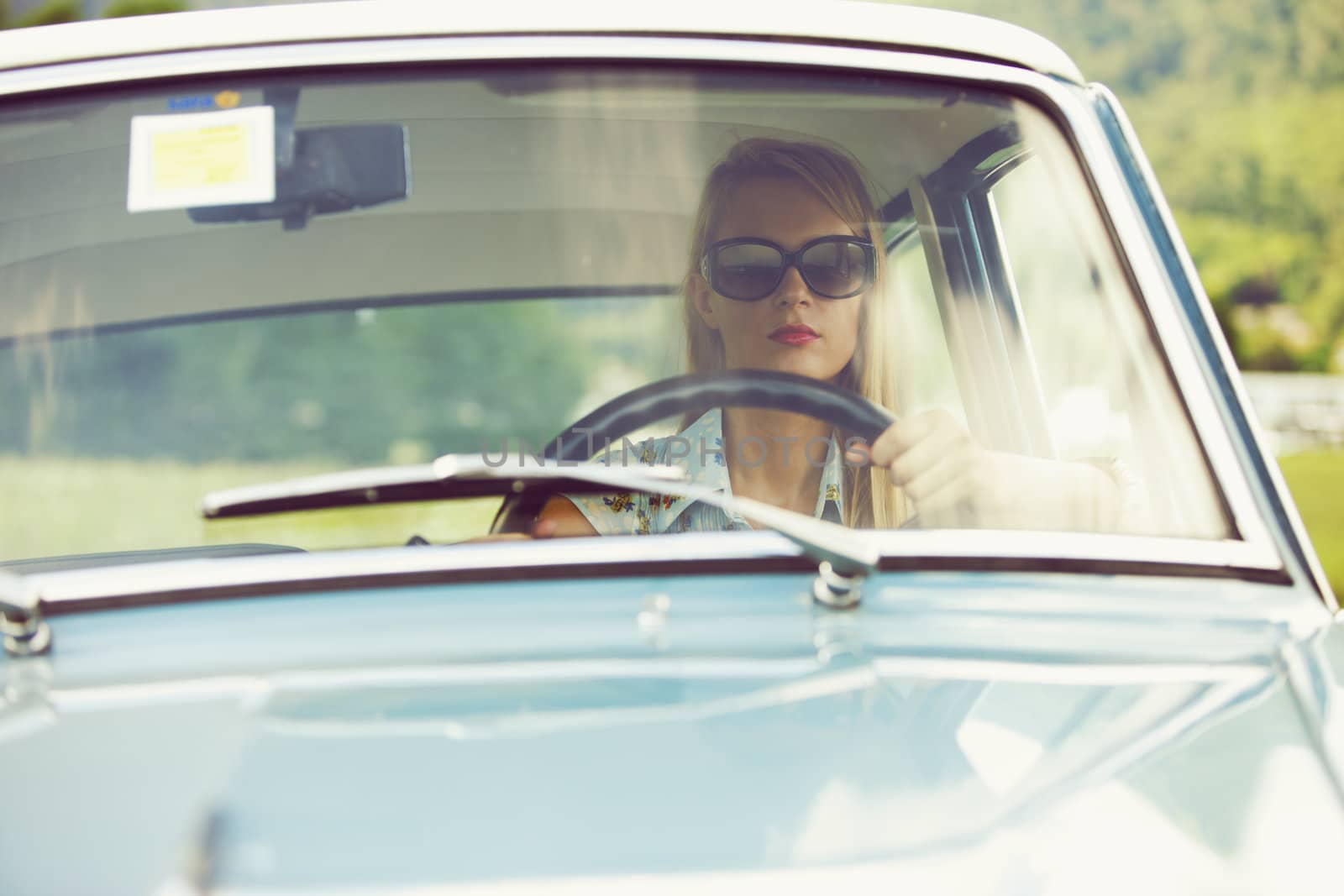 Young woman driving vintage car.