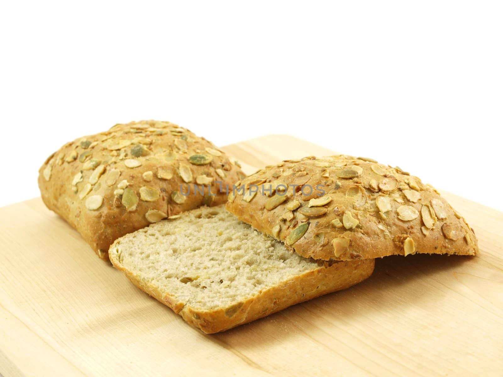 Bread with seeds isolated on a wooden board by Arvebettum